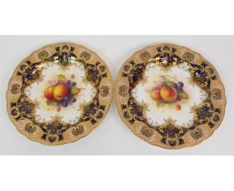 A PAIR OF ROYAL WORCESTER CABINET PLATES each painted with fruit within cobalt blue and gilt borders, and signed A Shuck, 23c