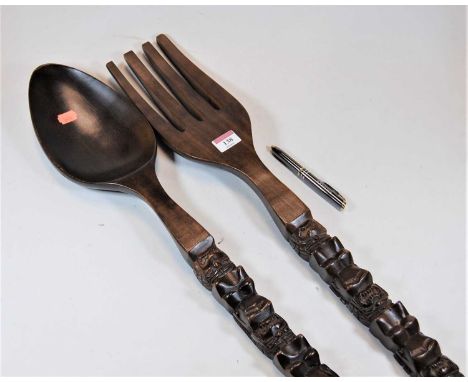 A novelty carved beech over sized fork and spoon, length 70cm