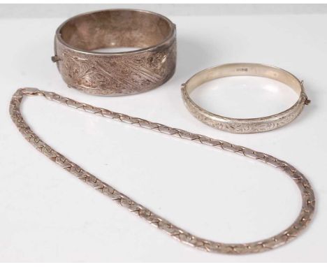 A Victorian style silver and engraved hinge bangle together with one other smaller example, and a white metal necklace stampe