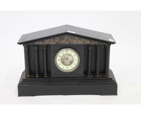 A 19TH CENTURY BLACK SLATE ARCHITECTURAL MANTLE CLOCK with white enamel dial and Arabic numerals, the movement bearing a stam