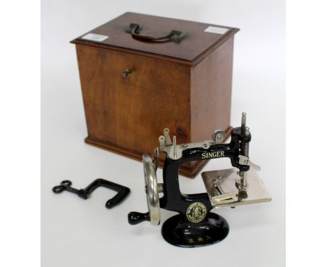 A 20TH CENTURY CHILD'S MANUAL SINGER SEWING MACHINE  in a 19th Century mahogany box, 21cm x 19cm x 15.5cm