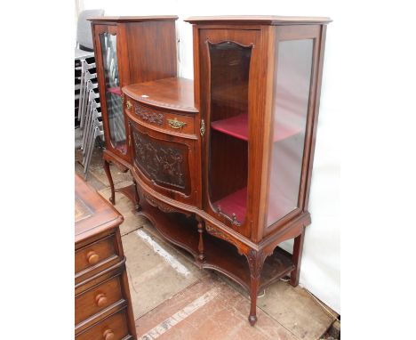 A LATE VICTORIAN MAHOGANY CABINET with twin glazed doors either side of a bow fronted single door, with carved decoration, ov