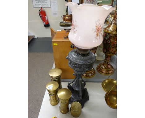 Three ornamental brass postboxes and a cast metal oil lamp with floral decorated pink glass shade