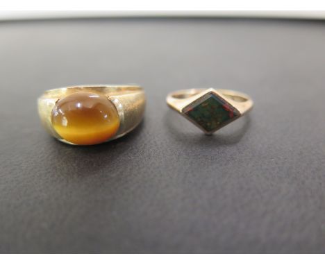 A 9ct gold tigerseye cabochon ring - Ring size S - Together with a bloodstone panel ring - Ring size L 1/2 - Both hallmarked 