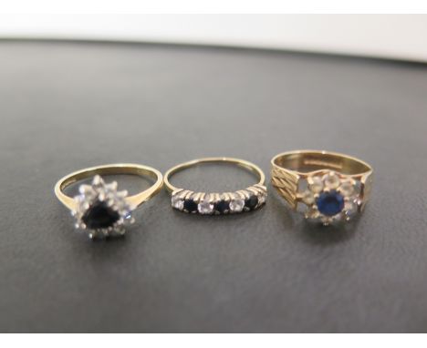 Three 9ct gold sapphire and white-gem rings - To include two clusters and a seven-stone - Hallmarked London and Birmingham - 