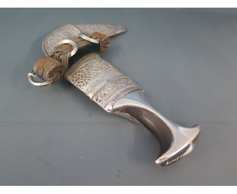 An Arabian Jambiya, the grip covered with silver and horn, in decorative silver mounted scabbard early 20th century