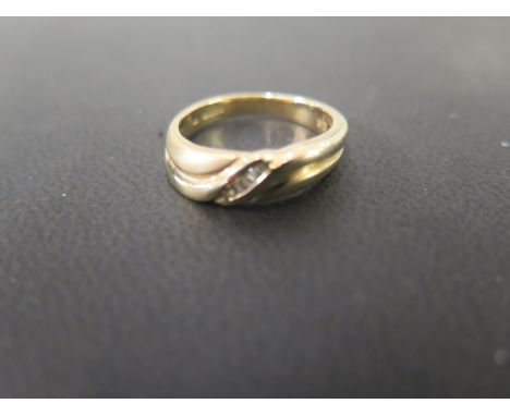 A 9ct gold diamond twist-style band ring - Set with baguette-cut diamonds - Hallmarked Sheffield - Ring size N - Weight appro