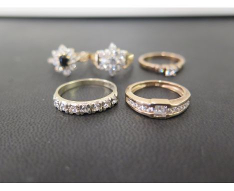 Four cubic zirconia rings - Together with a cubic zirconia and sapphire cluster ring - All with marks indicating 9ct gold - R