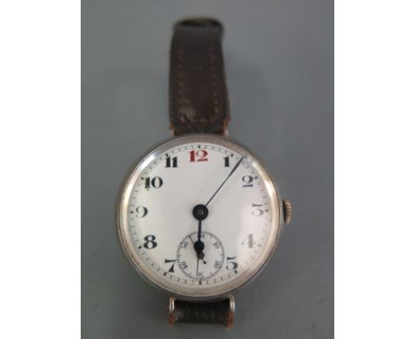 A silver cased trench watch hallmarked import marks for 1914, the hinged back opening to reveal movement, the white enamelled