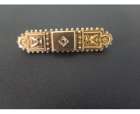 A late Victorian 15ct gold brooch - Set with an old-cut diamond, with bead detail -  Hallmarked Chester, 1889 - Width 4.5cms 