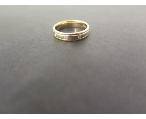 An 18ct bi-colour gold band ring set with three brilliant-cut diamonds - Hallmarked London - Ring size L - Weight approx 3.7g