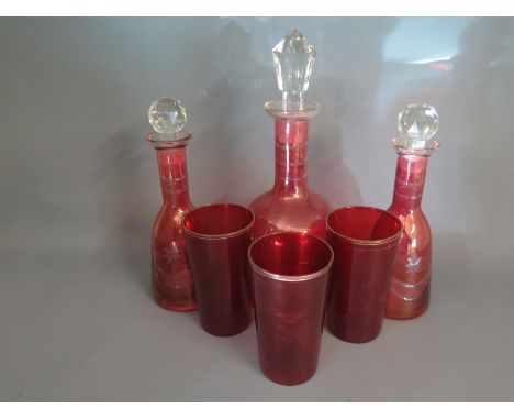 Three ruby glass decanters and three glass tumblers 