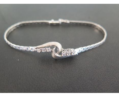 A diamond twist style bracelet - The six brilliant-cut diamonds to the woven bracelet - Stamped 585 (14ct gold) - Length 19cm