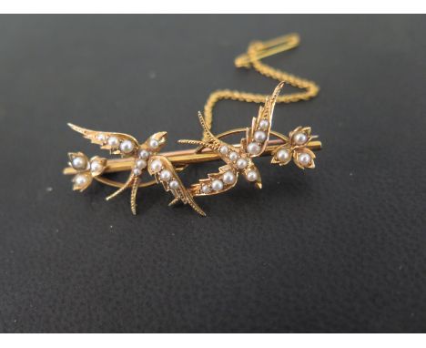 An early 20th century gold seed pearl swallow and leaf brooch - Width 4.5cms  - Tests as higher carat gold, with possible 9ct