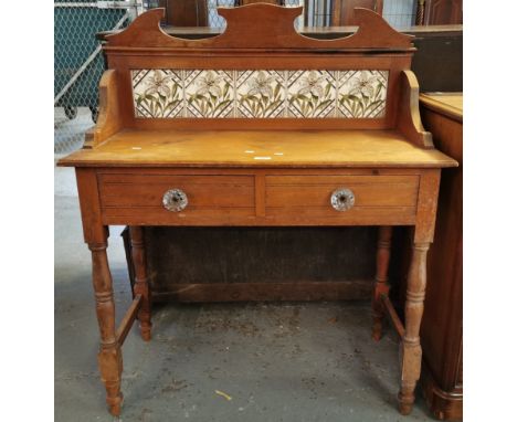 Early 20th century pine tile back wash stand, having two drawers with glass fluted handles on baluster turned legs. (B.P. 21%