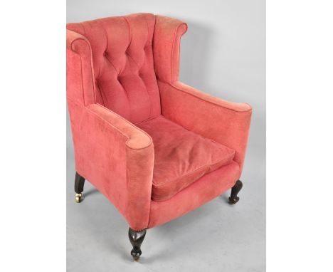 An Early/Mid 20th Century Button Upholstered Wing Armchair with Scrolled Arms and Brass Castors 