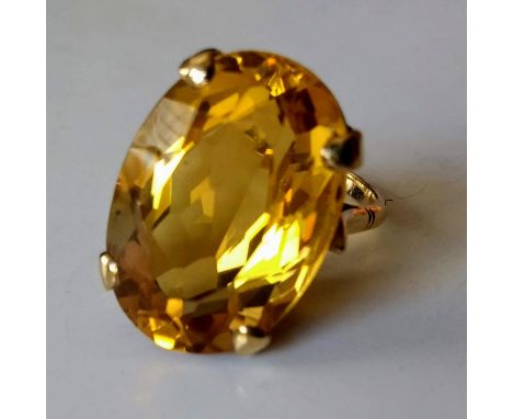 An oval citrine stone dress ring on 9ct yellow gold: the mixed-cut citrine 22.6mm x 15.5mm x 10.6mm, approx. 22.4 metric cara