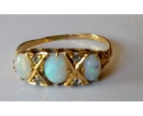 An Edwardian 18ct yellow gold seven-stone opal and diamond ring comprising three oval cabochon-cut white opals, measuring fro