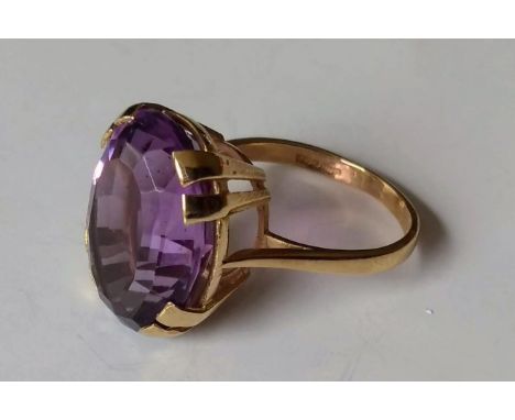 A 9ct yellow gold oval amethyst ring in a claw setting, 17.73 x 13.05 x 9.17mm, 12.96 carat on a double bezel coronet, size O