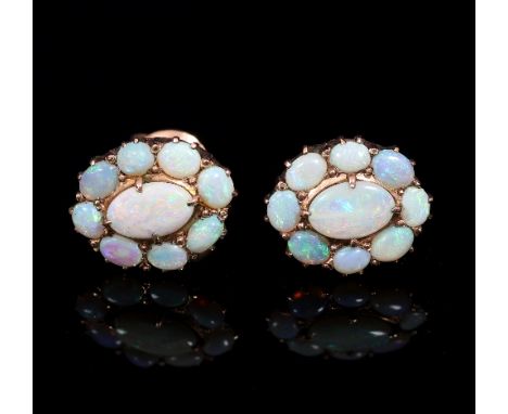 A pair of opal cluster ear studs, each with central oval opal to a surround of eight smaller opals