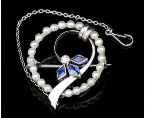 A sapphire, diamond and seed pearl brooch of circular stylised design, set in 14ct white gold, 2cm diameter
