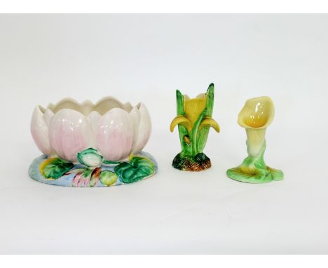 A Clarice Cliff jardinière of lily flower and pad form, a Carlton Ware lily flower head vase and another