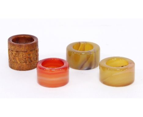 Three Chinese hardstone rings and a carved ivory ring