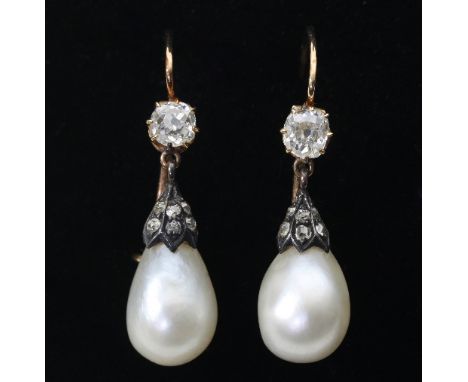 A pair of diamond and natural pearl ear pendants, each diamond capped pearl suspended beneath a single cushion shaped diamond