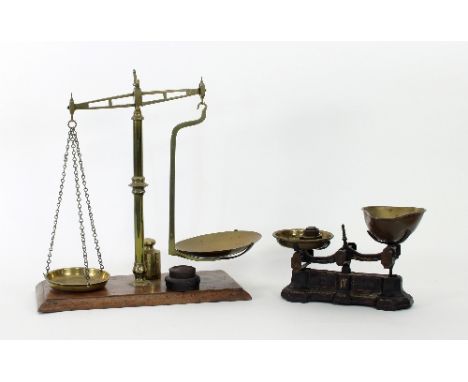 A set of 19th Century brass scales mounted on a mahogany plinth, 45cm high, together with a later pair of brass scales, marke