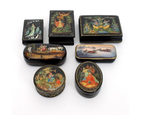 A group of seven Russian Palekh boxes, the largest of rectangular form depicting a snow scene, inlaid with mother-of-pearl, 1