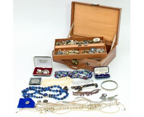 A large quantity of costume jewellery including strings of beads, earrings, enamel brooches, RAF badges etc., in a leather je