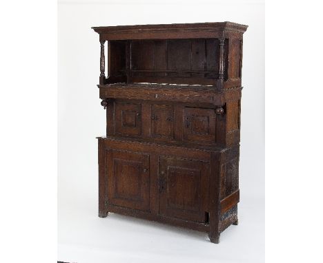 A Welsh oak tridarn, circa 1700, the moulded cornice upon turned columns above a recessed cupboard with two panelled doors ab