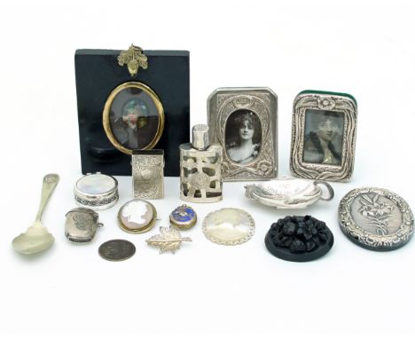 An oval miniature painted on porcelain, 2.5cm x 2cm, in an ebonised frame, two small silver photograph frames, a carved mothe