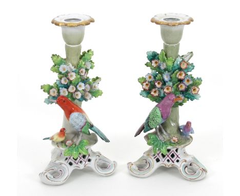 A pair of German Sitzendorf porcelain figural candlesticks, modelled as birds within flowering bushes on a tripod base, 21cm 