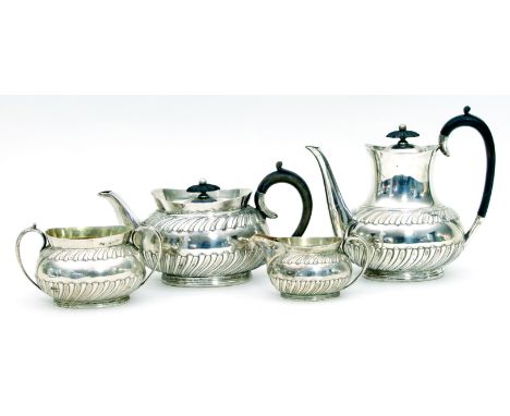 An Edwardian four-piece silver tea set, Sheffield 1901, of half lobed design, the tea and coffee pot each with ebony handle a