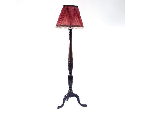A mahogany standard lamp, carved with wheat sheaves and plumage, on three cabriole legs, 148cm high