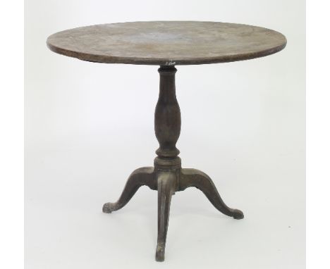 A mahogany circular tripod table, with tilt-top on a turned baluster column and three cabriole legs, 81cm diameter