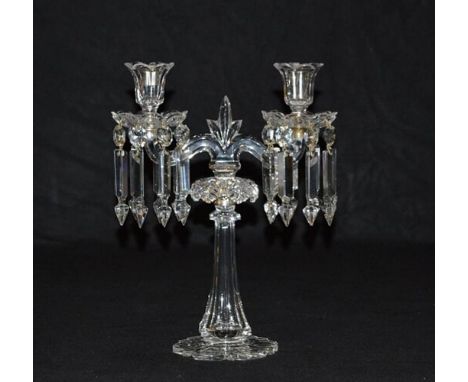 A pair of cut and moulded clear glass twin light lustre candelabrathe upward scrolling arms with lotus urn nozzles and scallo