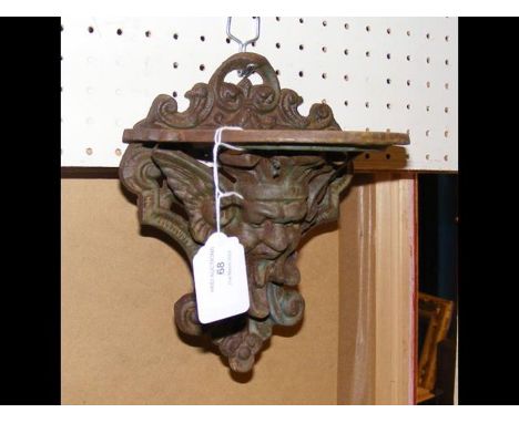 A cast iron Victorian wall shelf with mask design CONDITION REPORTAll metal.DimensionsHeight, 20cmWidth, 17cm