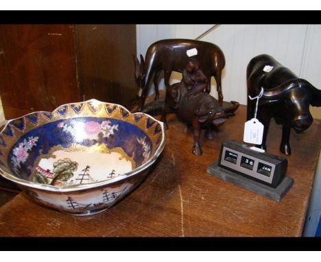 A vintage desk calendar together with a decorative Oriental bowl and several wooden animals