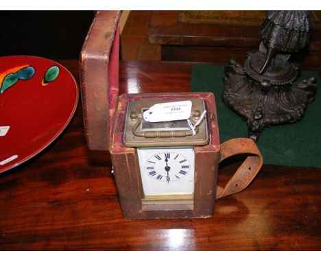 A brass cased carriage clock in leather travelling case