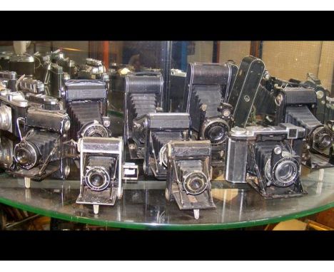 Nine vintage folding cameras including Zeiss Ikon