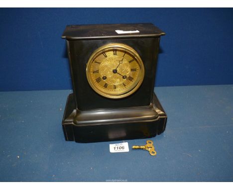 A small black slate Mantle clock having brass coloured face, Roman numerals, two chimes, with key and pendulum, 8 1/2" wide x