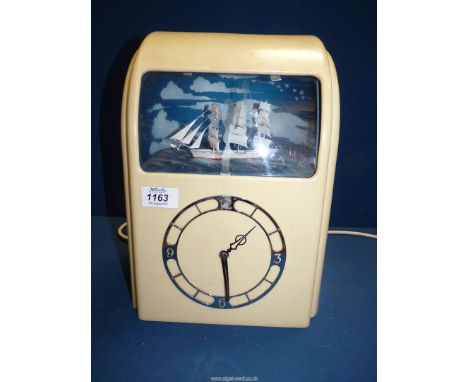 A 'Vitascope' Mantle clock in cream Bakelite case and with an illuminated model ship set above the chrome clock face, needs r