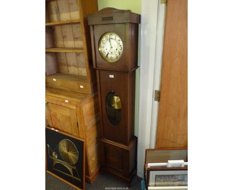 A 1940s/50s Oak cased Longcase Clock having a silvered face with Arabic numerals, the three train spring driven movement havi