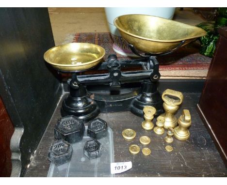 A pair of vintage brass kitchen scales with weights.