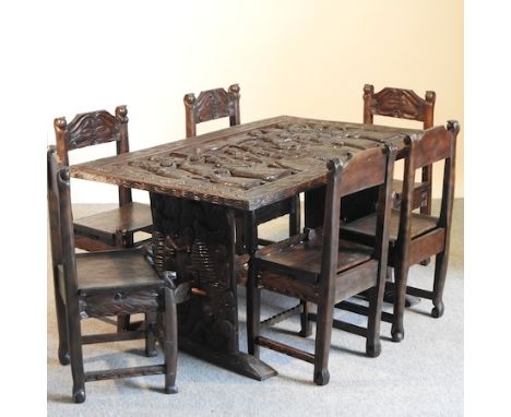 An African carved hardwood dining table, decorated with figures, 143 x 93cm, together with a set of six matching dining chair