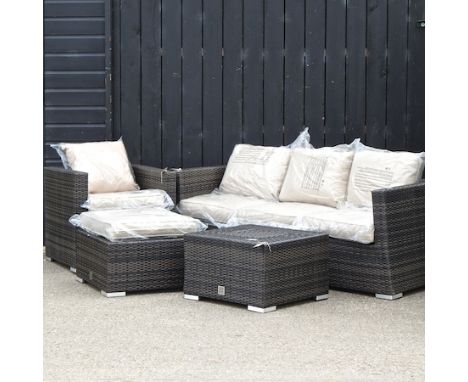 A rattan three seater sofa, 182cm, together with an armchair, a coffee table with integral ice bucket, a matching seat and cu