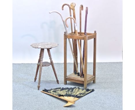 A collection of walking sticks, contained in a stick stand, together with a carved occasional table, 34cm