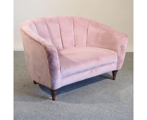 A pink upholstered shell back sofa, 135cm